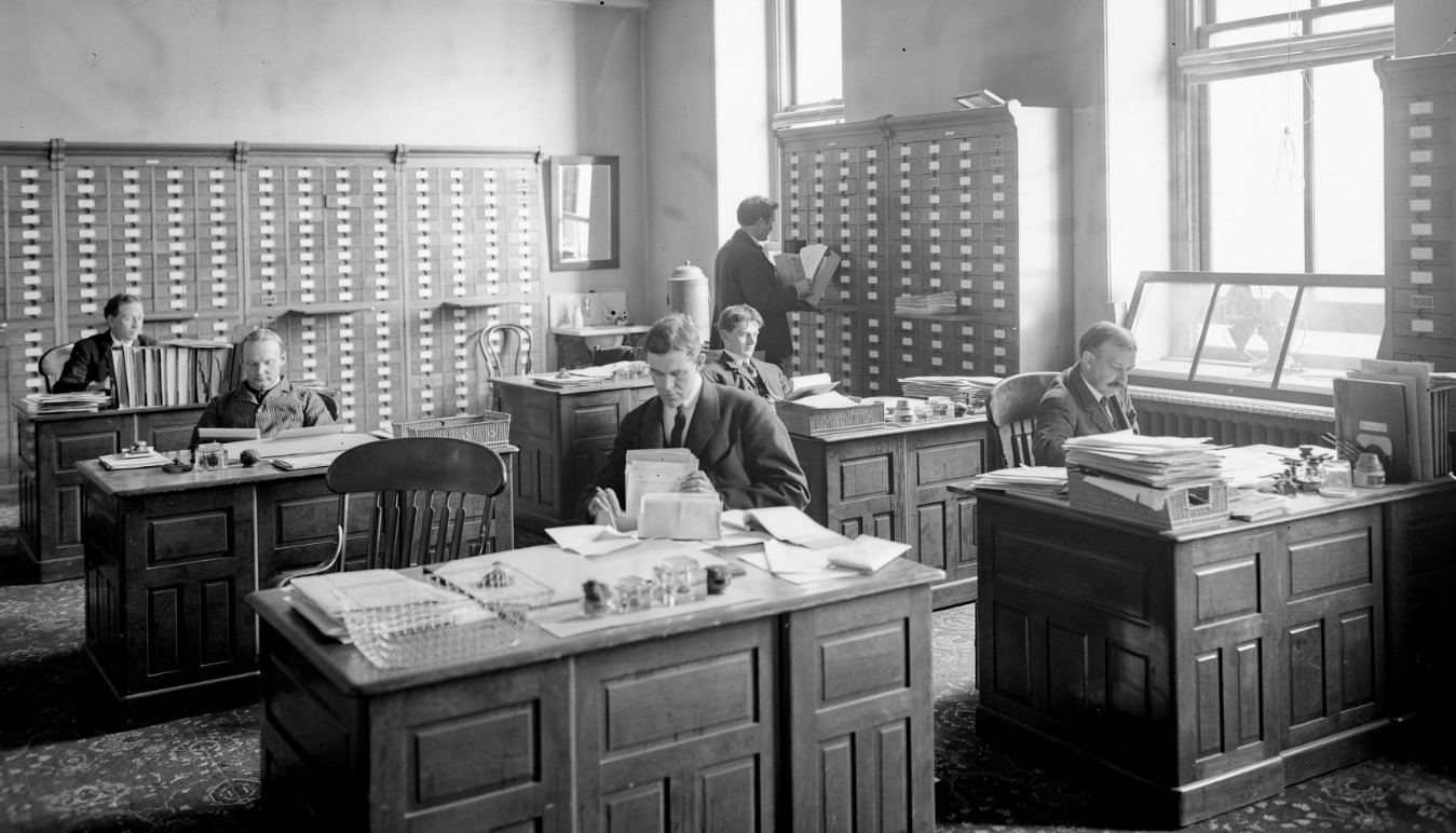 Image of six men working in a historic office 