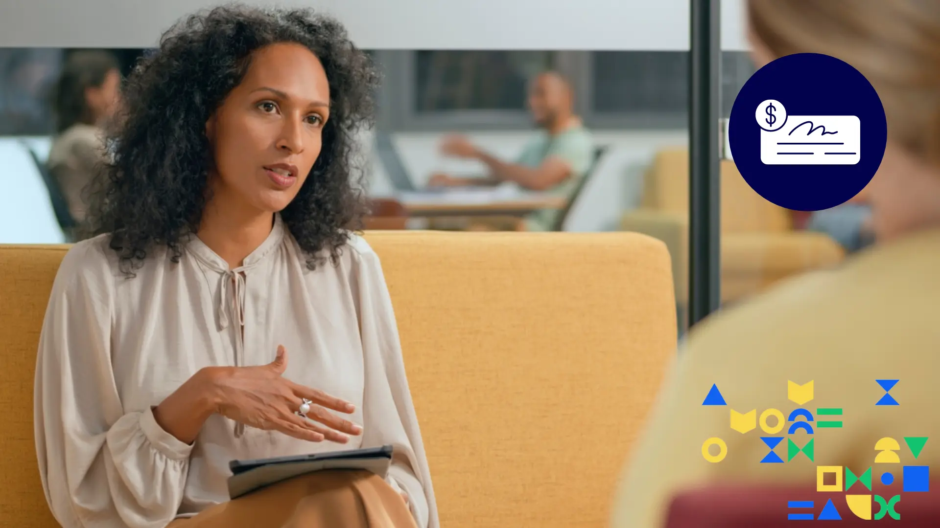 Image of a Gen X woman in a professional setting with a tablet on her lap conversing with someone else; an icon of a check overlays 